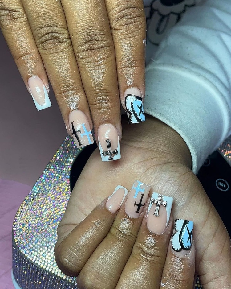 A close-up view of chic acrylic nails adorned with intricate designs in light brown and blue.