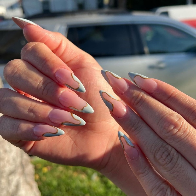 Elegant nails featuring a pink and aqua design, highlighted with unique patterns in a bright setting.