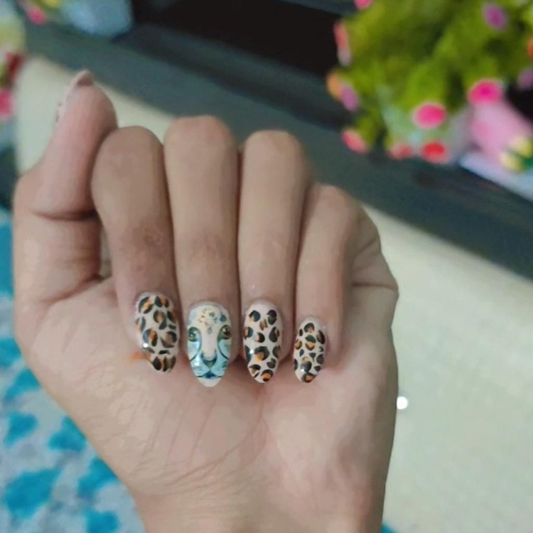 Colorful animal print nails featuring blue accents and intricate designs.