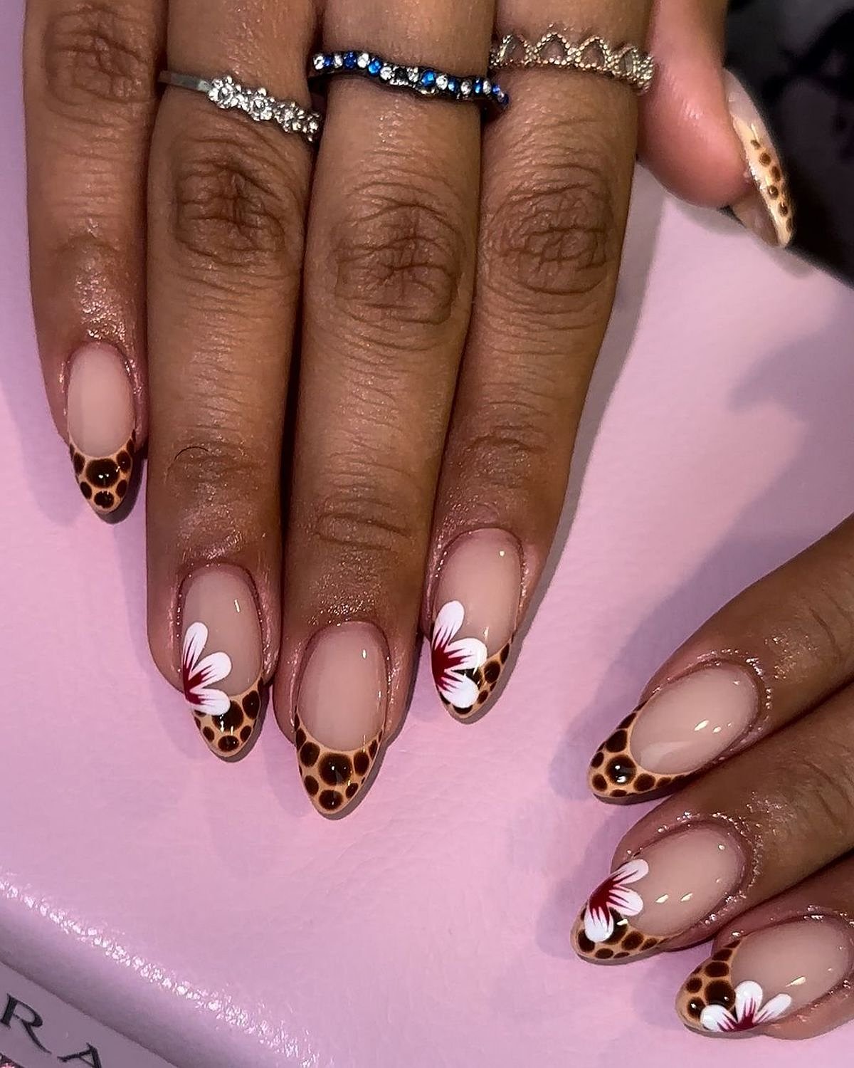 Beautiful nails featuring a unique animal print design in brown and pink with floral accents.