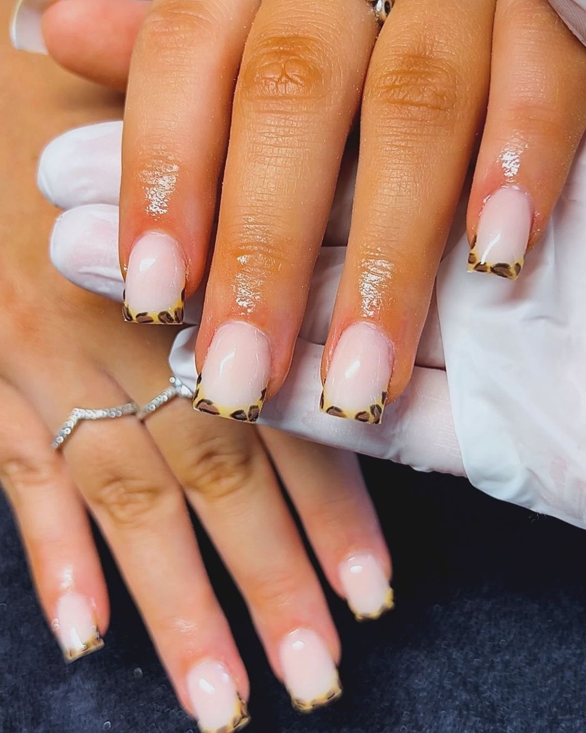 Beautiful nails featuring a pink base with gold and animal print tips, enhancing the overall aesthetic.