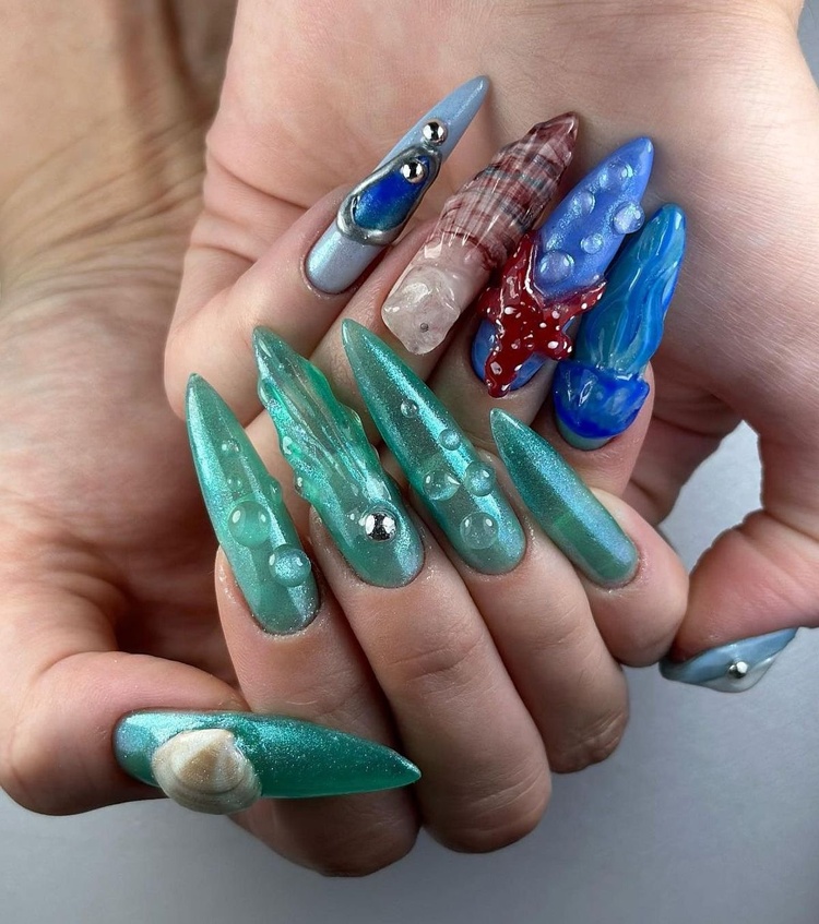 Aqua blue and teal nails featuring unique textures, sea shells, and glossy finishes on well-manicured fingers.