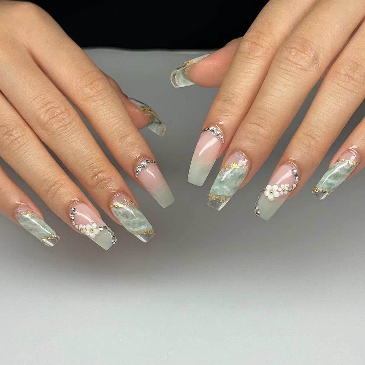 Close-up of stunning aqua nails with decorative pearls and glitter accents, showcasing elegant nail art.