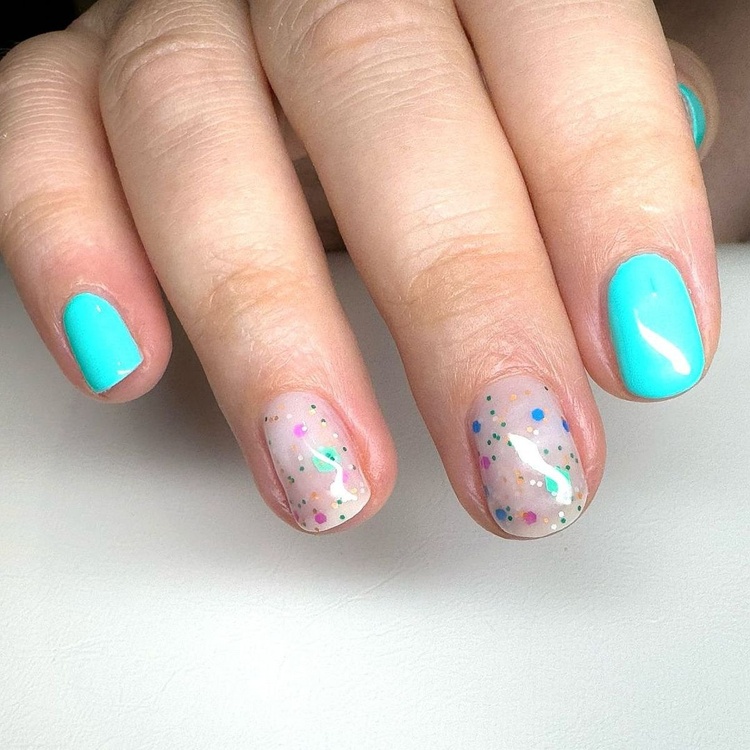 Bright aqua nails with a glittery accent nail featuring colorful specks, beautifully manicured fingers.