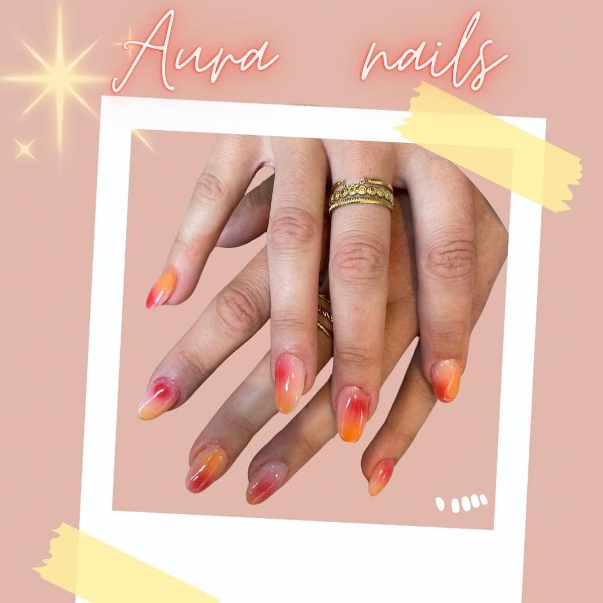 Close-up of elegant aura nails featuring a gradient of orange colors on fingers, with a soft background.