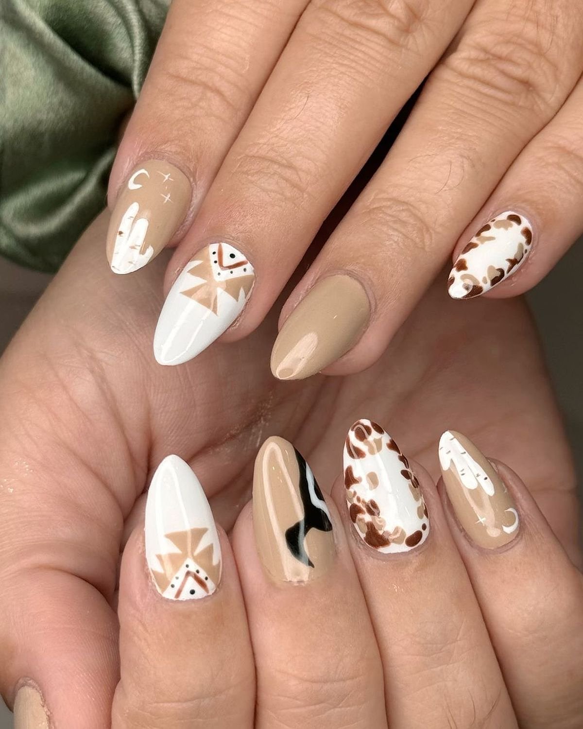 Beautiful arrangement of beige and brown nails featuring geometric designs and art, showcasing a creative manicure.