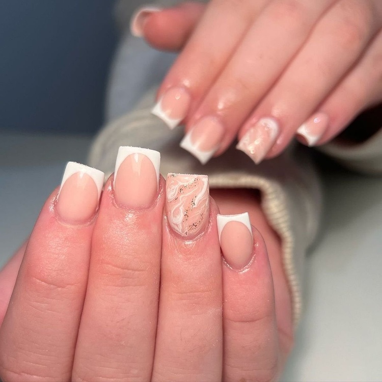 Beautiful beige and white French tip nails with artistic designs, showcasing a chic manicure.