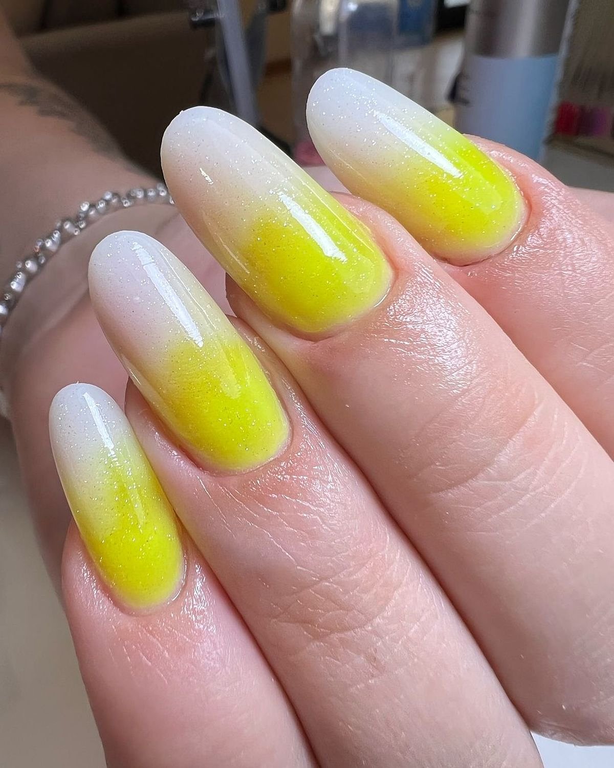 Vibrant yellow and white ombre nails with a glossy shine. Close-up of beautifully designed yellow and white ombre nails with a glossy finish.